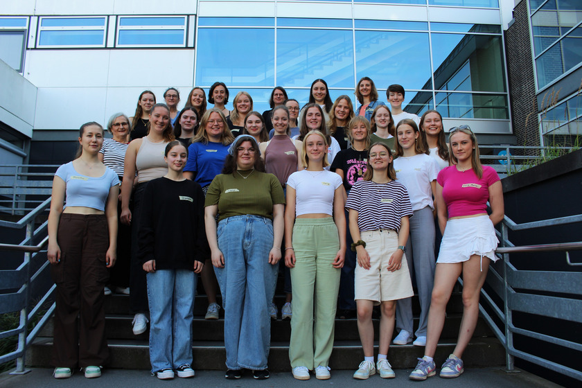 Gruppenbild mit jungen Frauen vor einem Hochschulgebäude.